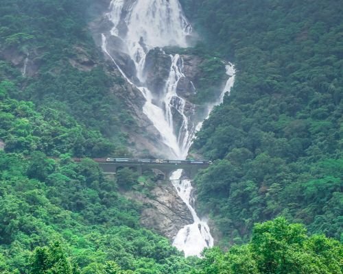 Full view of the Dudhsagar Waterfalls with train on track.