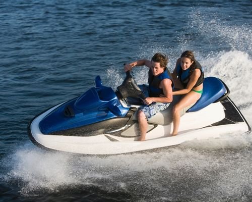 A Couple riding a Jet Ski on the waves of a Goan beach.